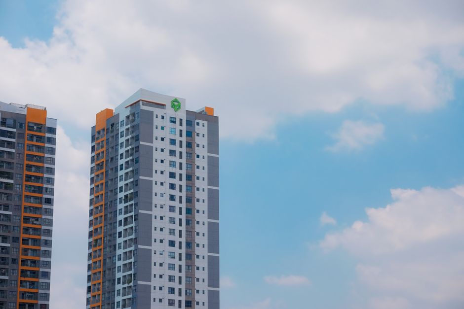 Contemporary high-rise apartment buildings with a clear blue sky backdrop, showcasing modern urban architecture.